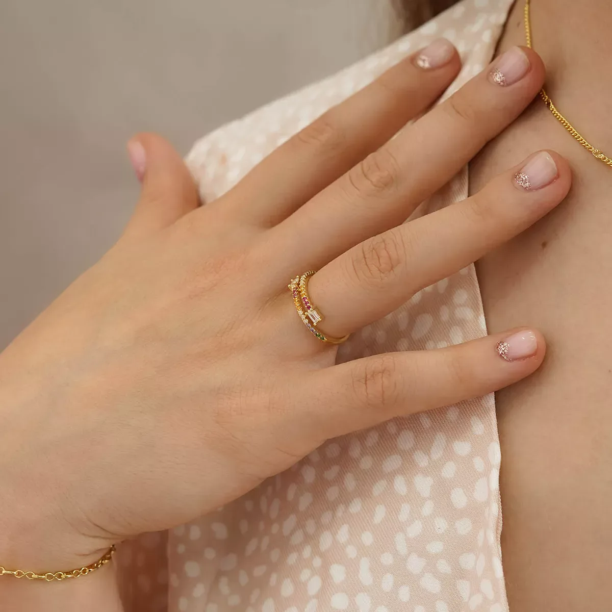 Anillo Sunrise en mano con tela rosa